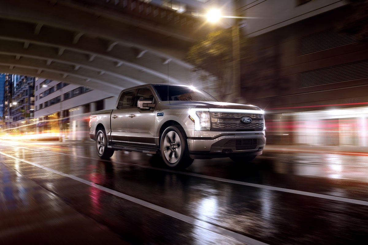 An F-150 Lightning® being driven in the city at night
